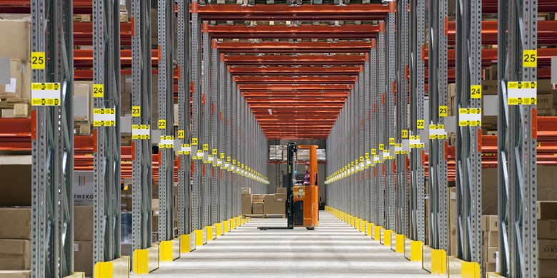 Wide-aisle pallet racking with a fort lift storing goods