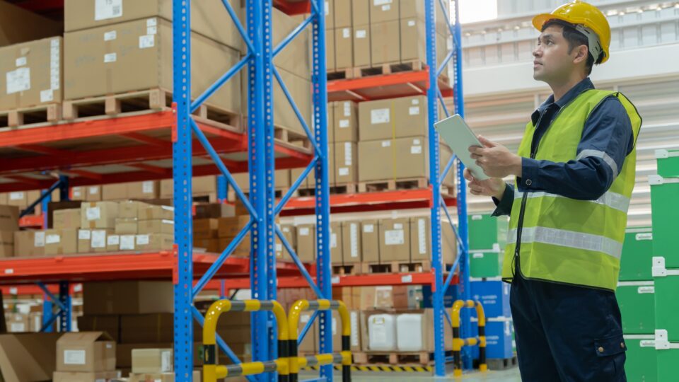 Man on a tablet in a warehouse performing a racking inspection